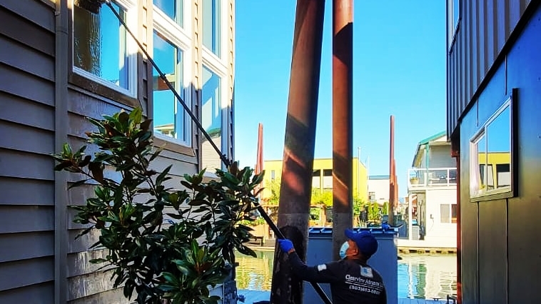 Clearview Advance technician cleaning windows at a floating-home dock
